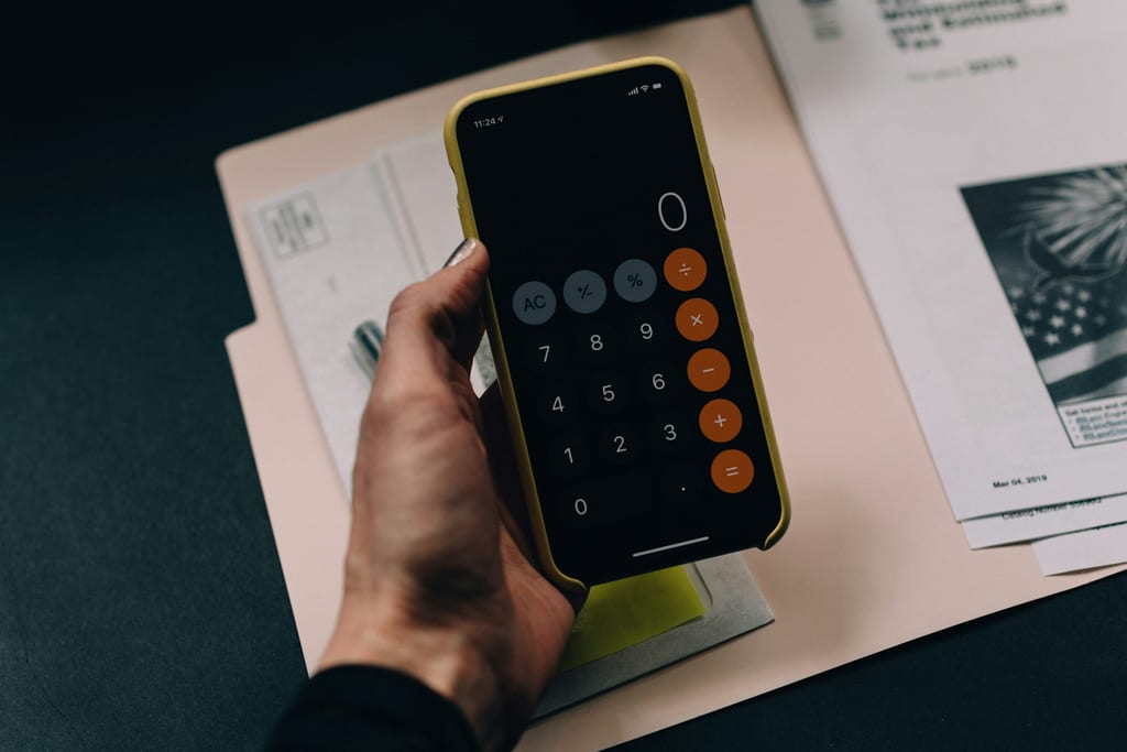 Documents fiscaux posés sur un bureau à côté d'un téléphone et d'un stylo